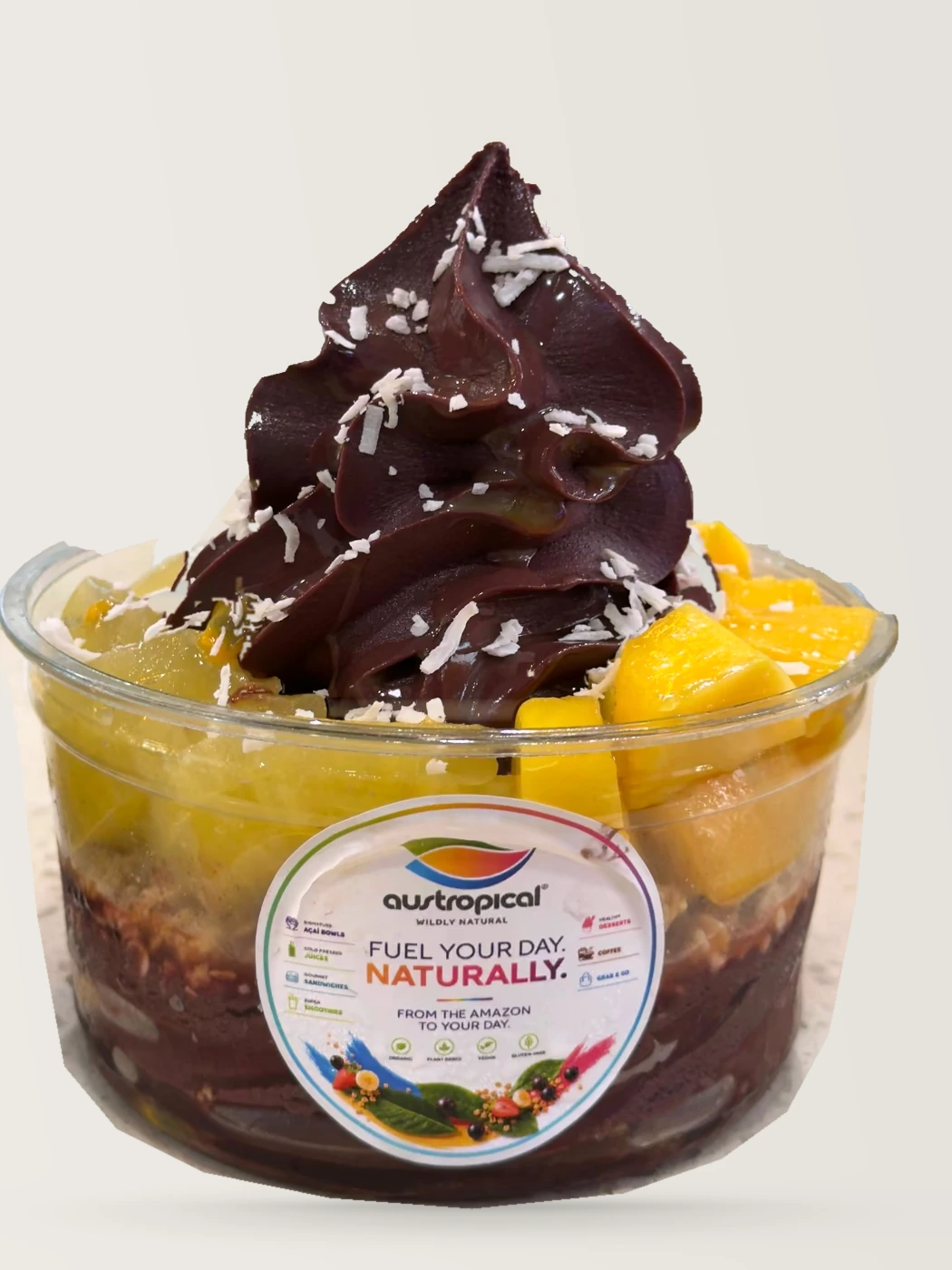 An açaí bowl topped with mango, kiwi and shredded coconut, on the café counter.