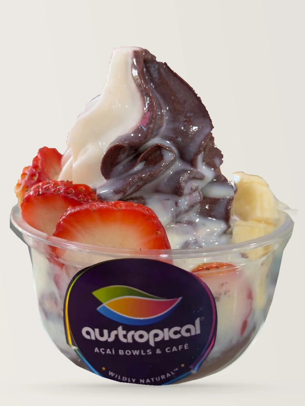 A two-tone swirl of açaí and white soft serve with strawberries in a clear Austropical cup.